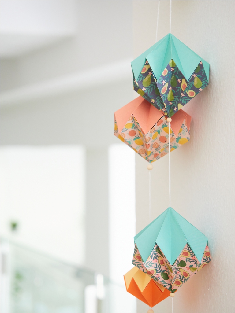origami garland hanging on the wall, abstract geometric decoration with paper
