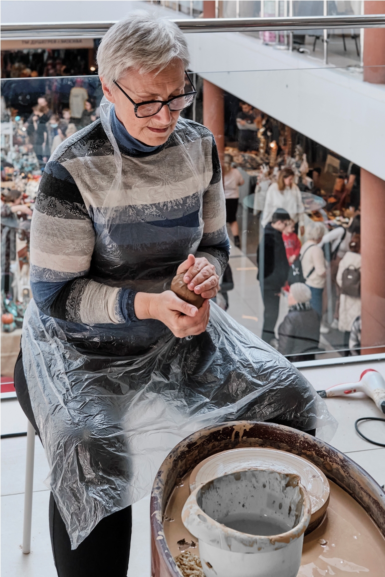 senior gray haired woman kneading clay in her hand 2023 03 21 14 45 27 utc