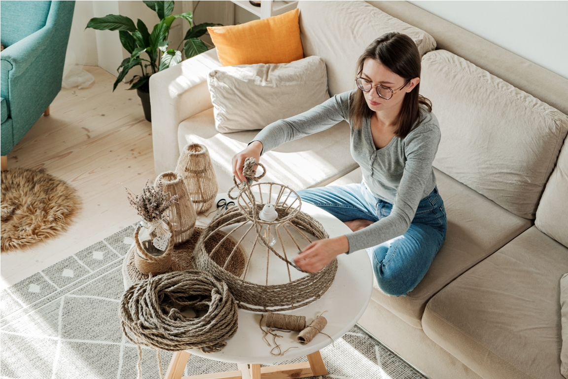 woman makes handmade diy lamp from jute rope at home