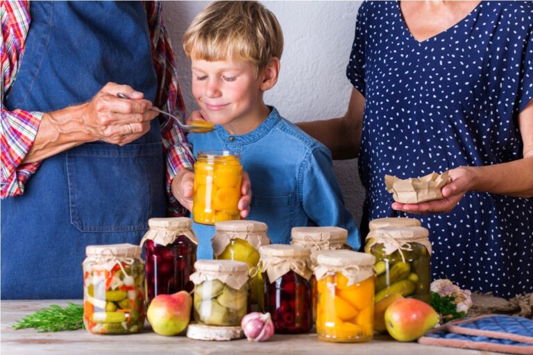 senior couple with grandson tasting fruit compote. harvest preservation