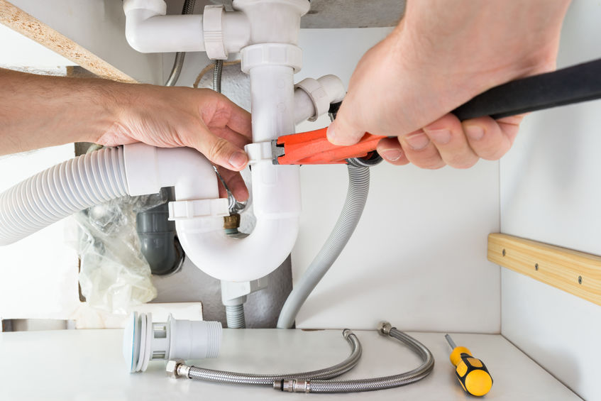 male plumber fixing sink in bathroom