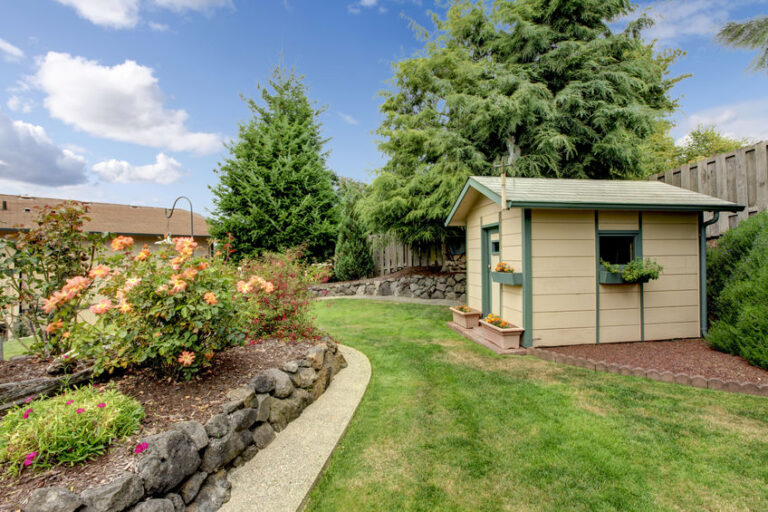 back yard with grass walkway, small gardening shack, and layered